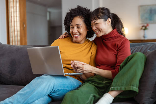 istock Lesbian couple relaxing at home and using a laptop 2175968019