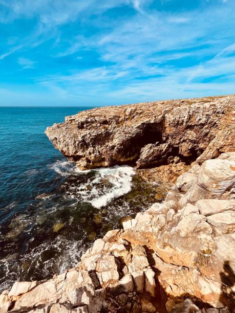 istock Rocky coastline with waves crashing under a bright blue sky 2175968579