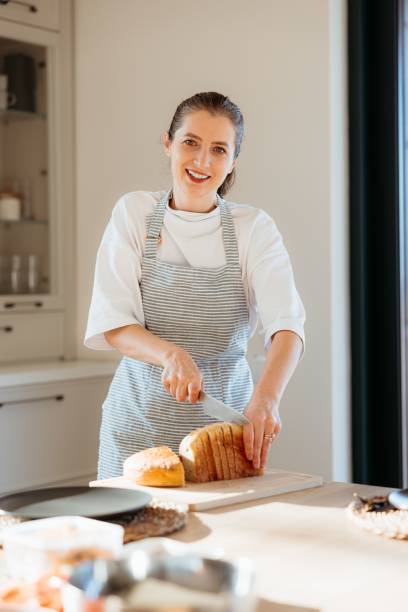 istock Female chef slicing fresh bread in modern kitchen 2175969084