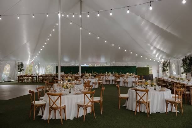 istock Elegant wedding reception tent with string lights and wooden chairs 2175969395