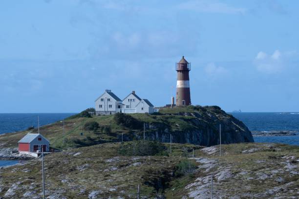 istock Lighthouse on a scenic island with houses. 2175969677