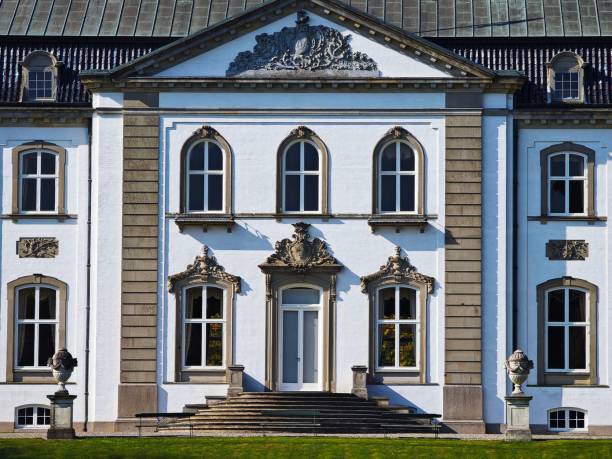 Facade of a historic European building with ornate architectural details and symmetrical windows.
