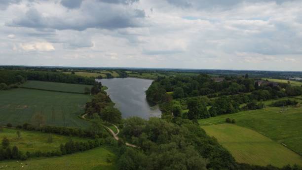istock Serene aerial view of a river winding through lush green fields and forests under a cloudy sky 2175970807