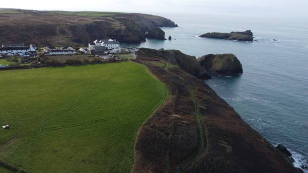 istock Aerial view of a coastal village with green fields and rugged cliffs. 2175970818