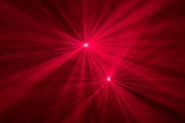 Red and pink lights defocused for a colorful abstract effect are placed at the top half of the image with softer blurred transition below it, fading into a vert dark background.