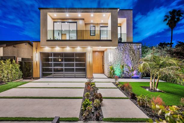 istock Modern two-story house illuminated at night with landscaped yard. 2175972673