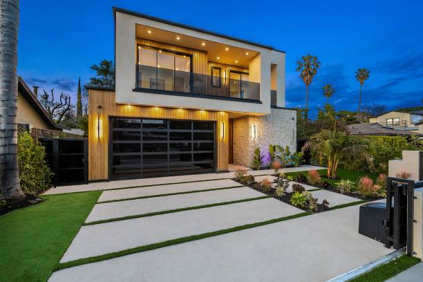 istock Modern two-story house with large windows and palm trees at dusk. 2175972704