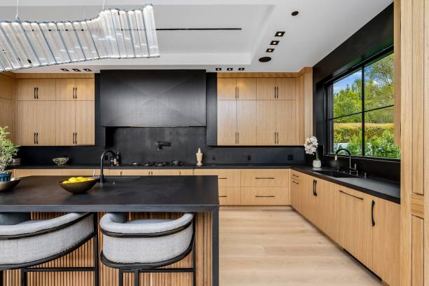 istock Modern kitchen with wooden cabinets and black countertops. 2175972727