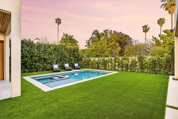 istock Modern backyard with a pool and lounge chairs under a pink sunset sky. 2175972888