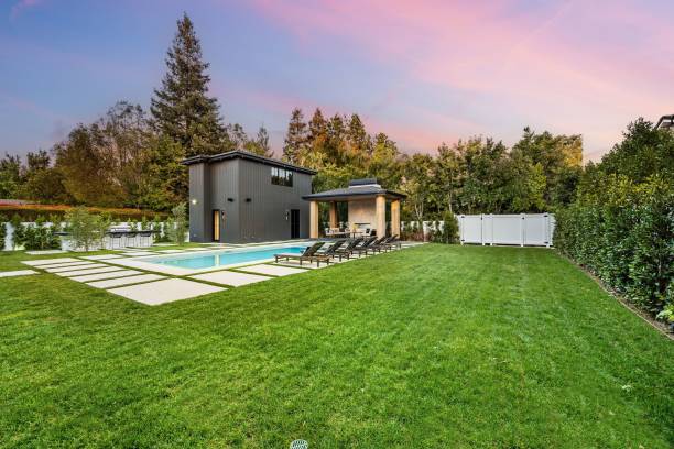 istock Modern backyard with swimming pool and lounge chairs at sunset. 2175972915