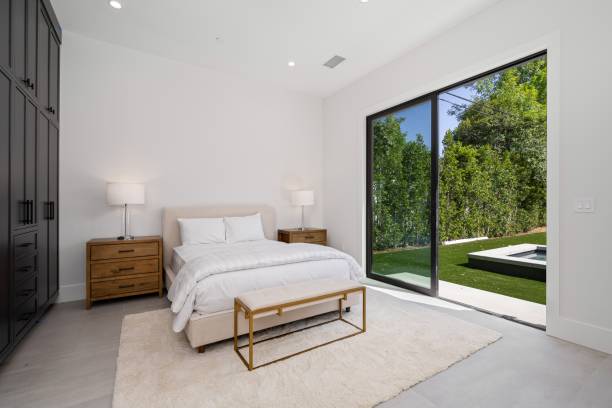 istock Modern bedroom with large glass doors opening to a backyard. 2175973603
