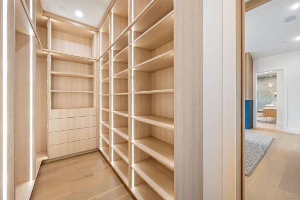 istock Modern wooden walk-in closet with ample shelving and drawers. 2175973697