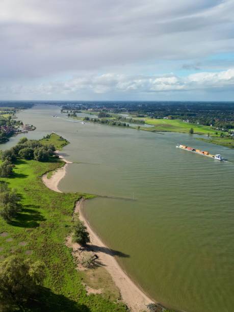 istock Aerial view of a river landscape with a cargo ship and lush greenery. 2175974016