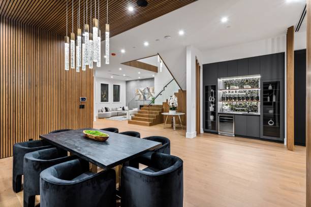 Modern dining and living area with stylish lighting, wooden accents, and contemporary furniture in a luxurious home interior.