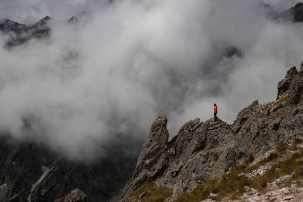 istock Lone hiker on a mountain peak with clouds 2175975630