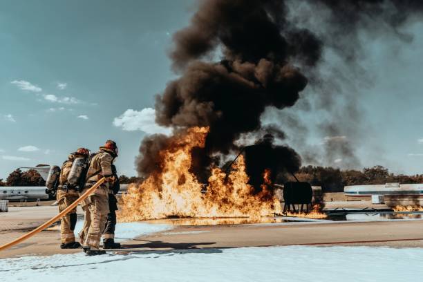 Heat waves partially obscure a team of firefighters preparing to attack a training fire.