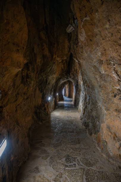istock Illuminated narrow cave tunnel with stone pathway 2175976015