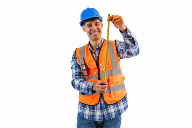 istock Smiling construction worker holding a measuring tape in safety gear white background 2175978473