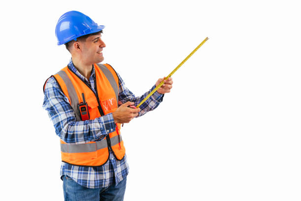 copyspace Happy construction worker with measuring tape and safety gear white background