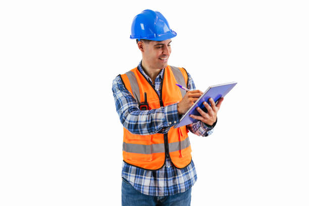 istock Engineer in reflective orange vest and helmet documenting project details on notebook 2175978653