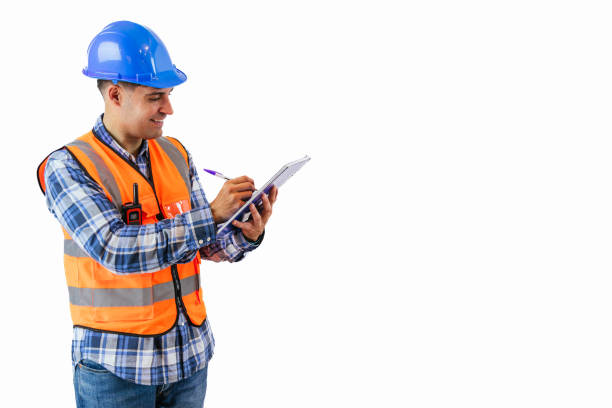 istock copyspace Engineer in reflective orange vest and safety helmet writing project notes in notebook 2175978662