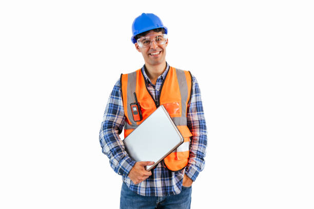 istock Construction worker smiling while holding laptop wearing safety glasses, helmet, and reflective vest 2175979290