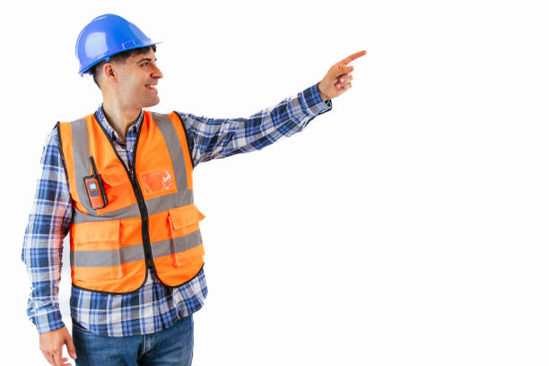 istock copyspace Construction worker pointing with finger at copyspace wearing orange vest and helmet 2175979363