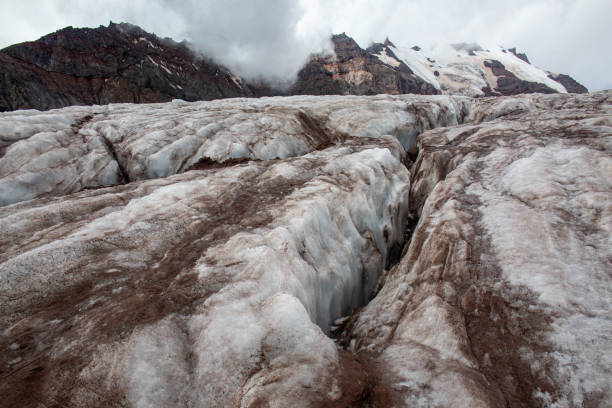 istock A vast glacier stretches out before a towering mountain, its surface cracked and textured. 2175997811