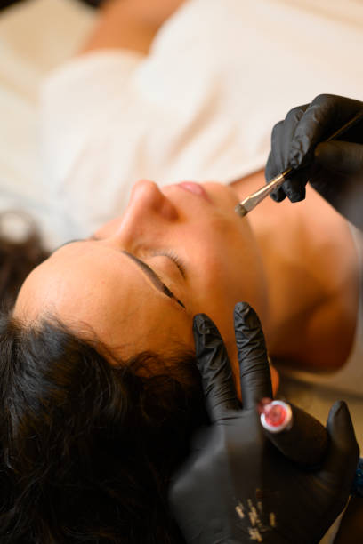 istock Beautician applying permanent eyebrow makeup on woman 2176015830