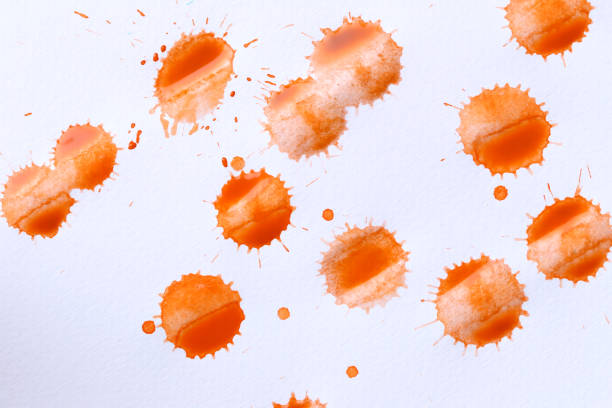 Orange color paint drops on paper, causing dispersion of color, use it for design your work concept.