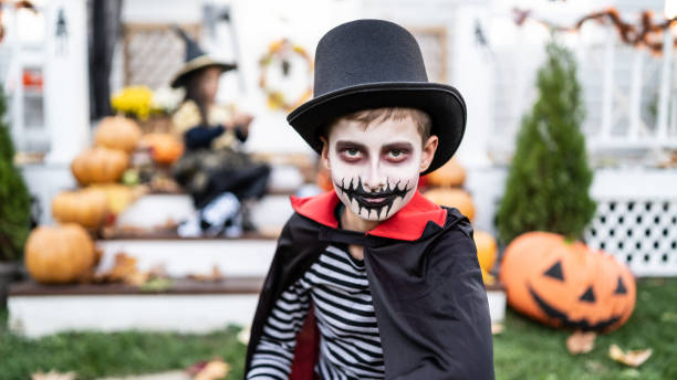 istock Boy dressed in Halloween costumes trick or treating at night during Halloween 2176024436