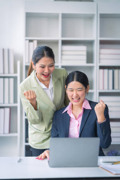 istock Two successful Asian businesswomen working with financial data graph documents and laptops in business data analysis. 2176024468