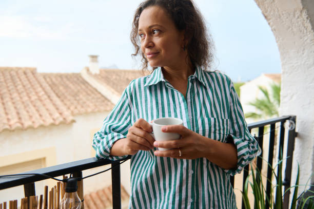 istock Woman enjoying morning coffee on a sunny balcony 2176024933