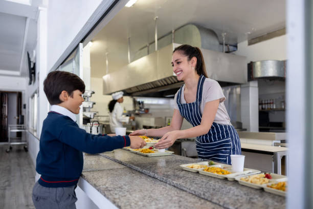 istock Happy waitress serving the school lunch to elementary students 2176025183
