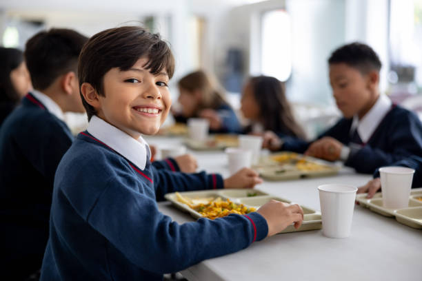 istock Happy student eating his school lunch at the cafeteria 2176025214