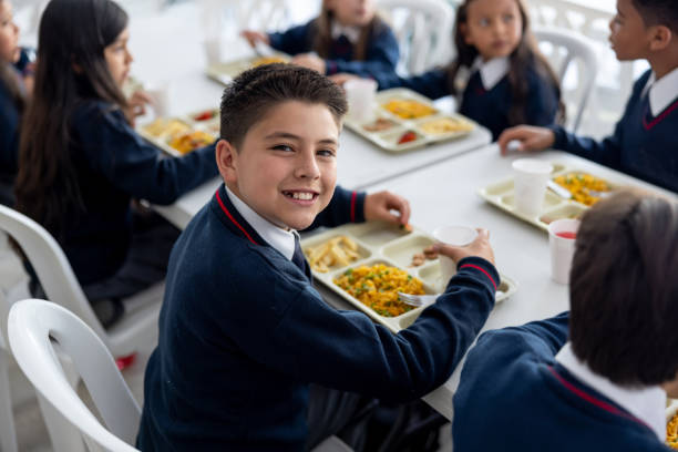 istock Schoolboy eating his school lunch at the cafeteria 2176025230