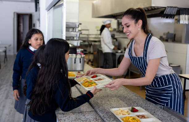 istock Happy waitress serving the school lunch to elementary students 2176025237