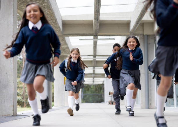 istock Happy elementary students running at the school corridor and going to recess 2176025239