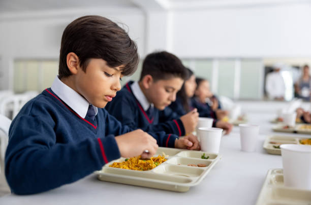 istock Schoolboy eating his school lunch at the cafeteria 2176025242