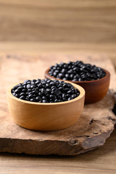 Black bean in bowl on wooden background