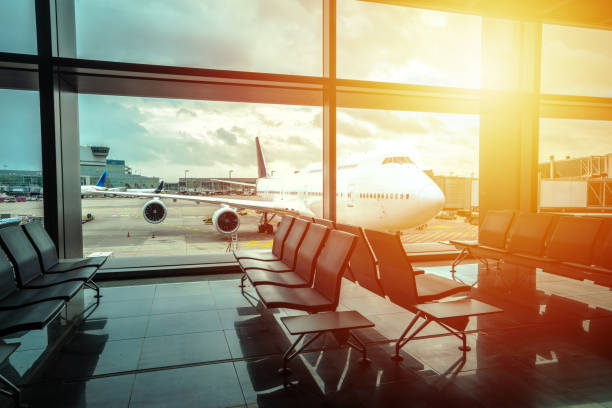 istock Airport gate waiting area and jumbo jet sunset view 2176044859