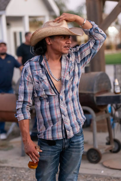 mature hispanic man looking away wearing a cowboy hat