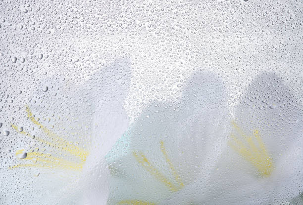 Water droplets on glass with yellow background