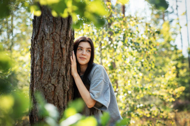 istock A young girl hugs a tree in the forest. 2176048775