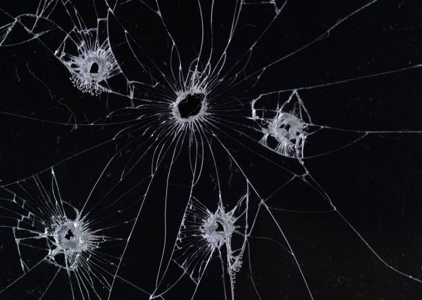 istock Broken glass bullet holes isolation on black background,Cracked glass 2176049192