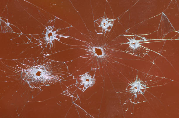 Broken glass bullet holes on orange background,Cracked glass