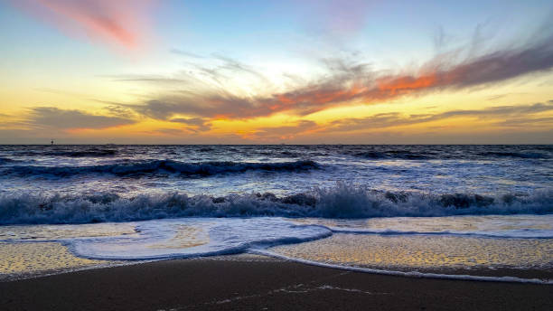 istock Sunsets as waves break to shore 2176053938