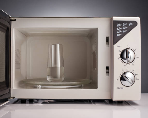 two old white and black microwave on white floor, white wall background, technology, object, ferniture, electricity; copy space