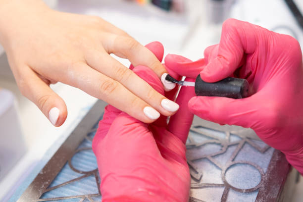 istock Client receives a top layer of gel polish application on her nails while relaxing in a nail salon. 2176059624