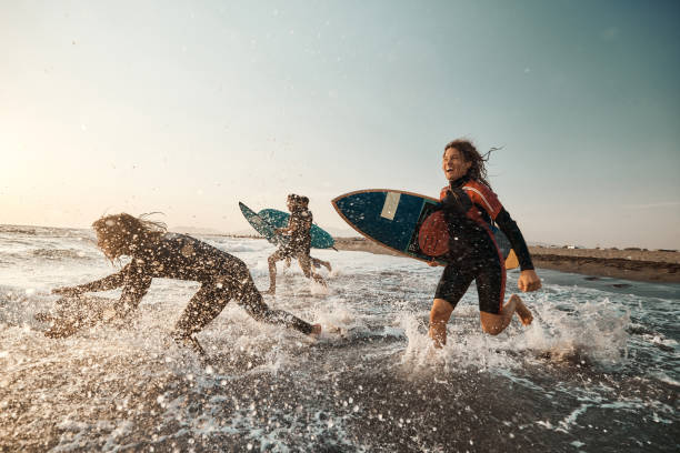 istock Carefree surfers having fun while surfing in sea. 2176060530